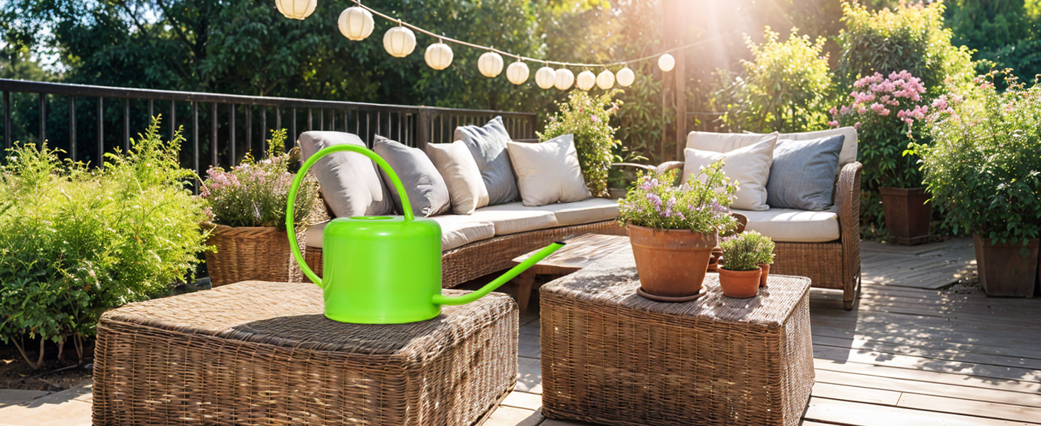 Green watering can on patio and garden setting