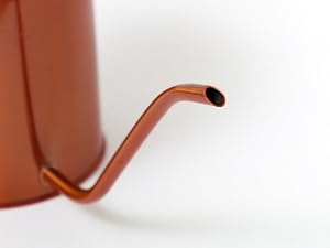 Long slender spout of rose gold watering can